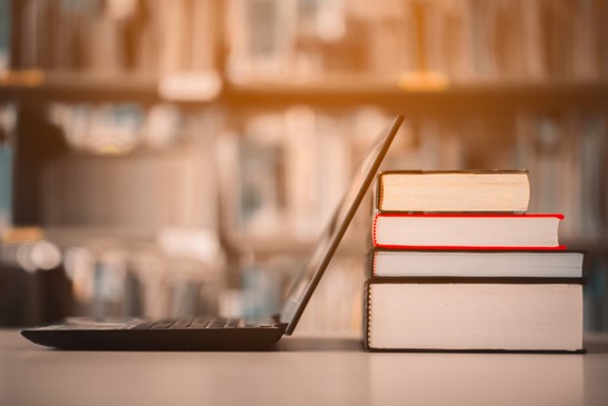 Ausbildung bei EWE Auf einem Tisch befinden sich ein Laptop und ein Stapel Bücher.