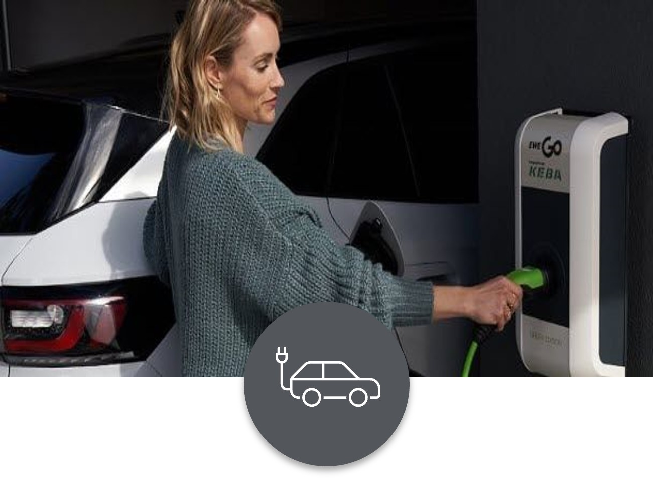 Wallbox-und-Autostrom Eine Frau steht an einer Ladestation und lädt ihr Elektrofahrzeug auf.