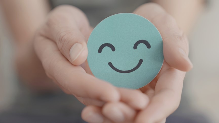 Über uns Dekoratives Bild Zwei Hände halten einen Smiley-Aufkleber, der Freude ausstrahlt.