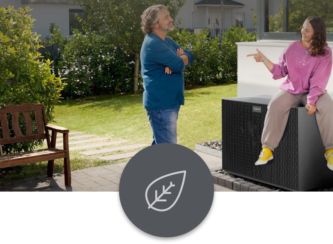 Wärmepumpe Ein Mann und eine Frau stehen im Garten, während die Frau auf einer Wärmepumpe sitzt.